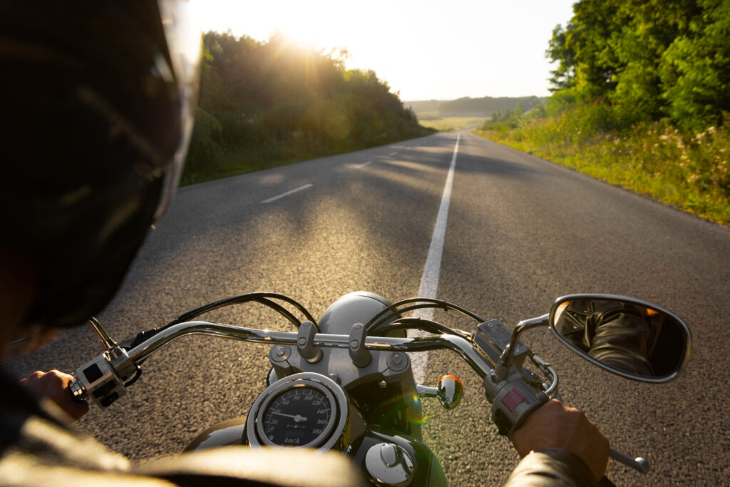 Ein Motorradfahrer genießt den Sonnenaufgang.