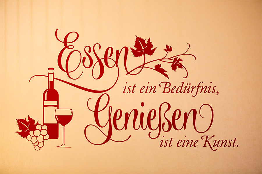 Wandposter mit dem Spruch: ‚Essen ist ein Bedürfnis, Genießen ist eine Kunst‘
