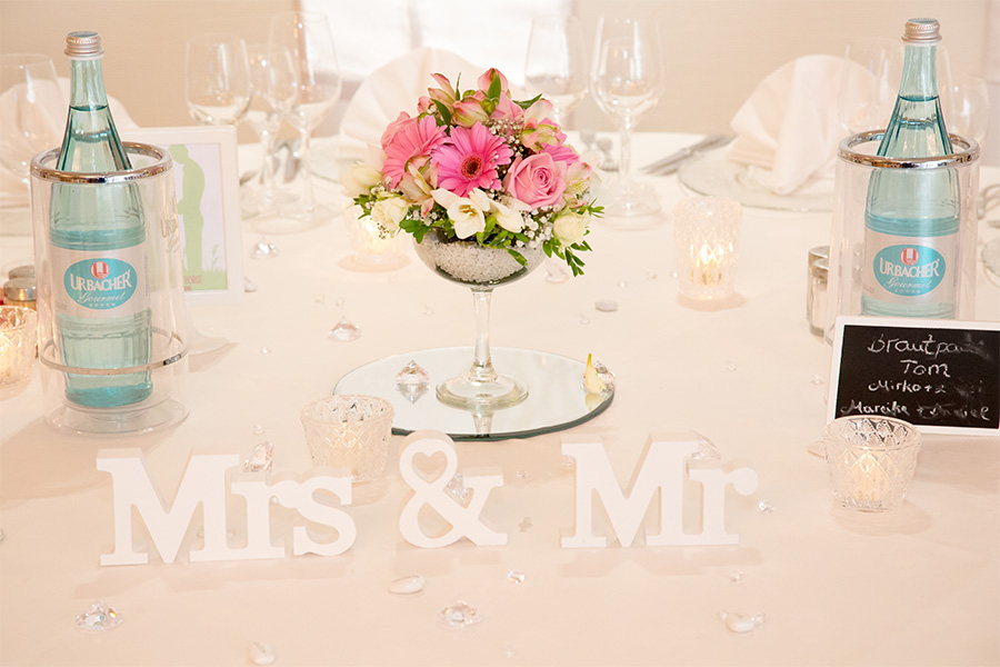 Tisch festlich für Hochzeit dekoriert mit Blumen und Gläsern